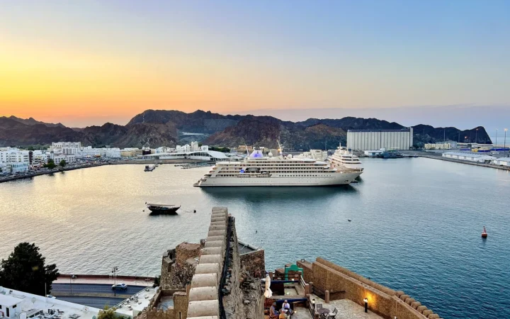 Muscat harbour and a cruise ship at sunset